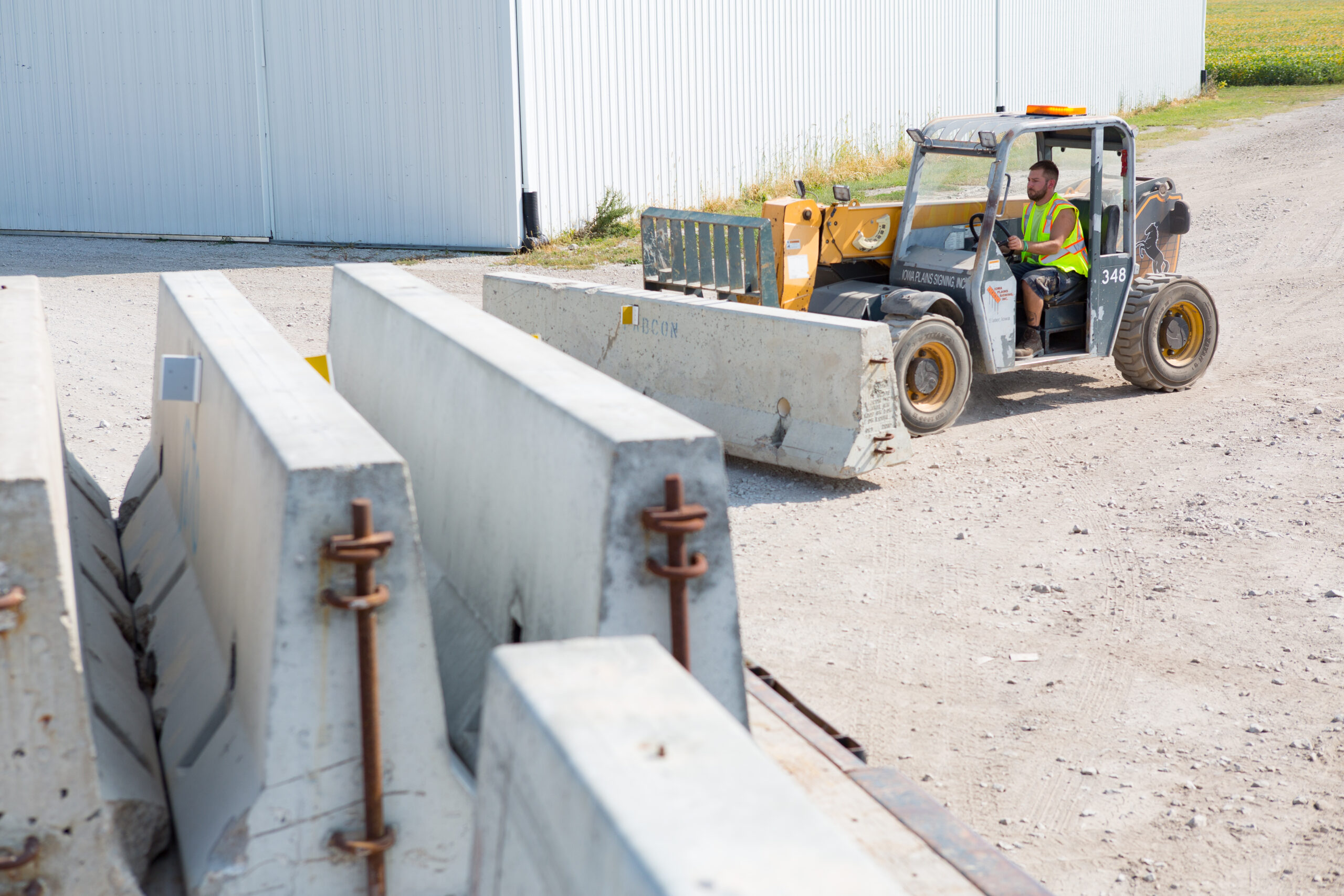 Todco worker moving concrete barricades with a forklift